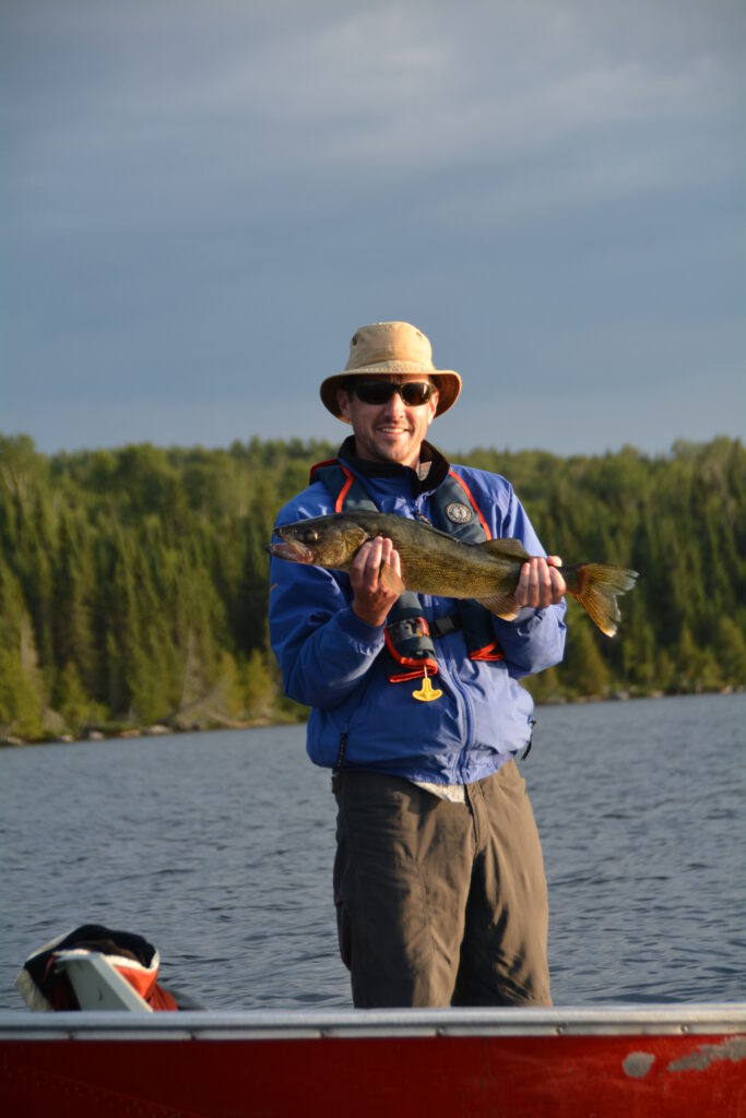 A gentleman holding a fish he caught at Duffy camp.