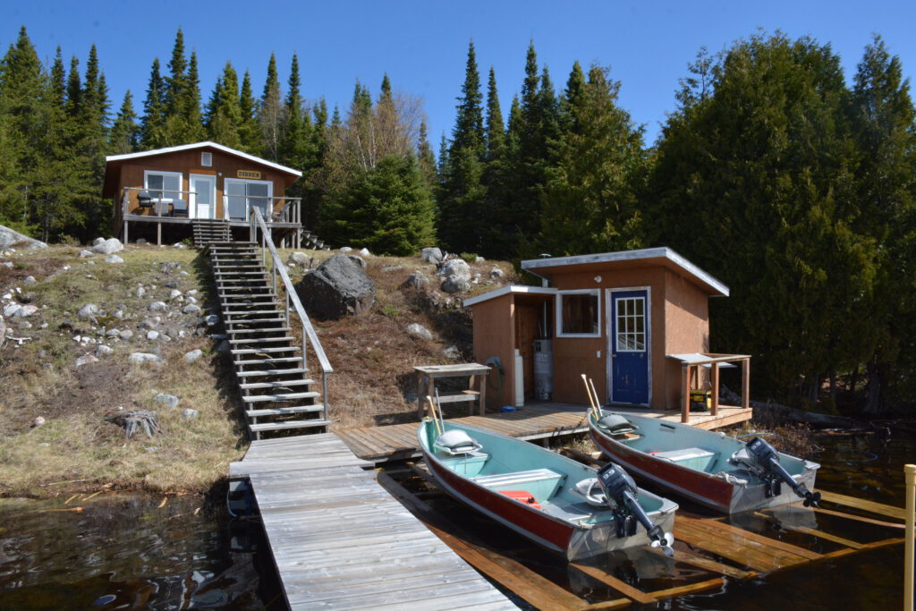 A photo of the cabin and boats at Dibben camp.
