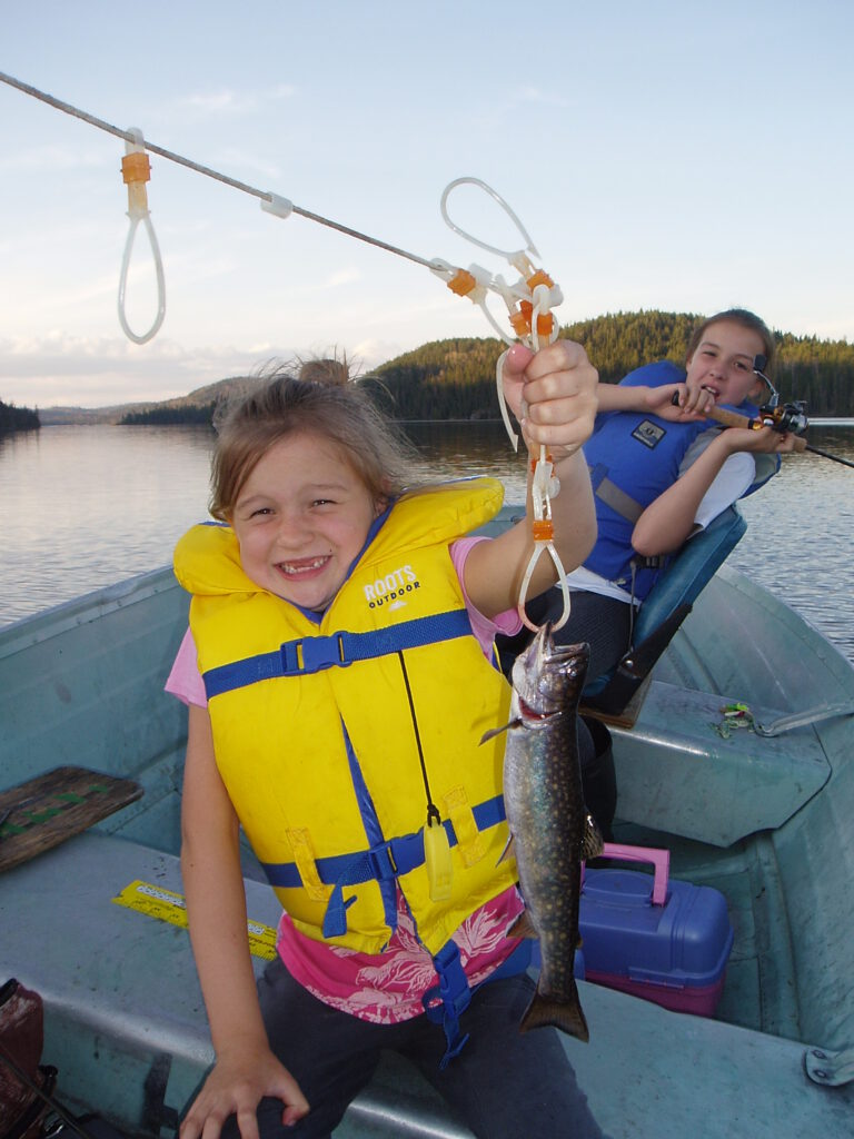 Two kids showing off the fish they caught at McCrea camp.