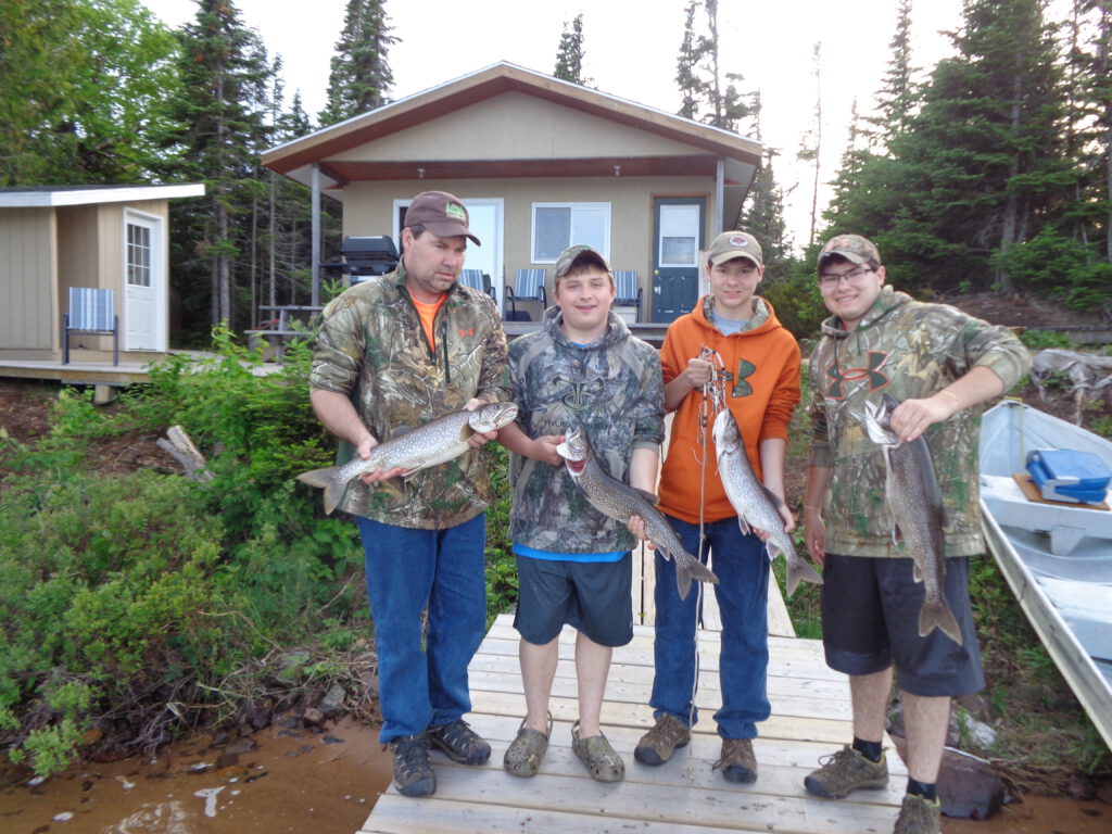 Four gentlemen showing off the fish they caught at Michi camp.